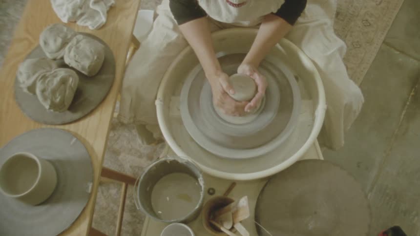 A person is spinning clay on a sculpting wheel