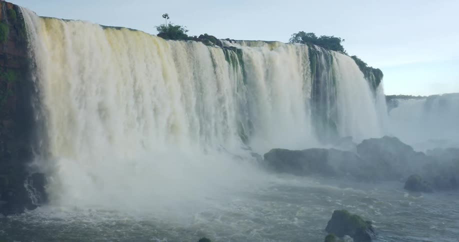 Iguazu falls roars as immense volumes of water cascade over the cliff edge generating a significant mist in the iguau national park