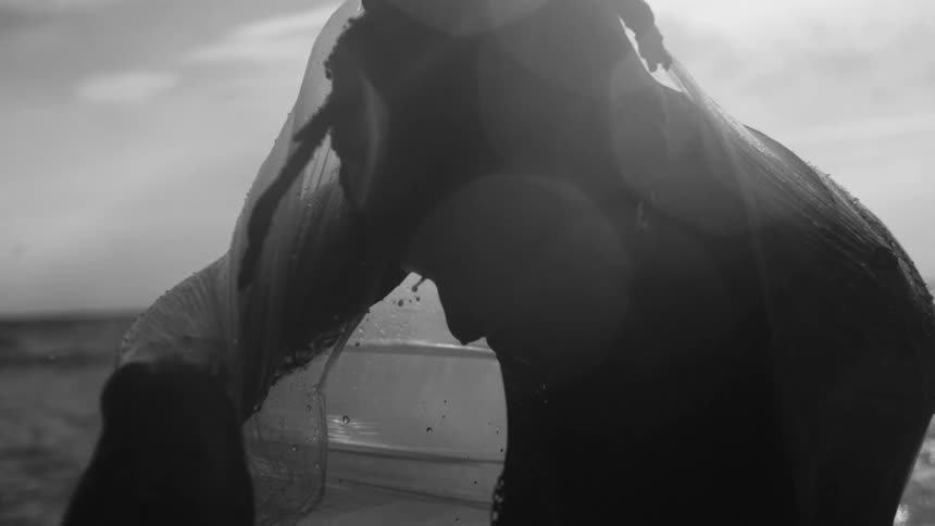 A man is soaking wet by the water