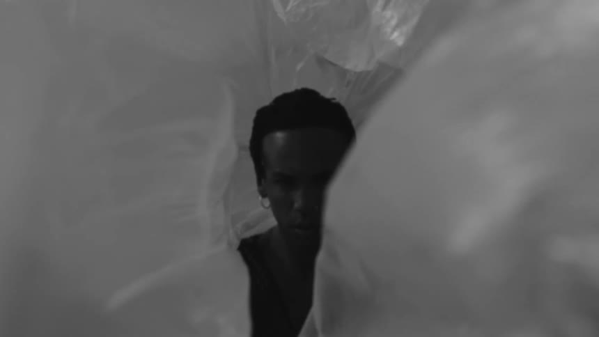 Fluttering plastic flows through the air to obscure the face of a man