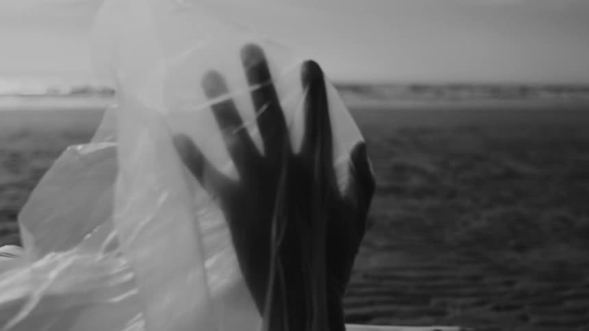 Plastic sheet covering the hand of a person standing outside flutters in the breeze