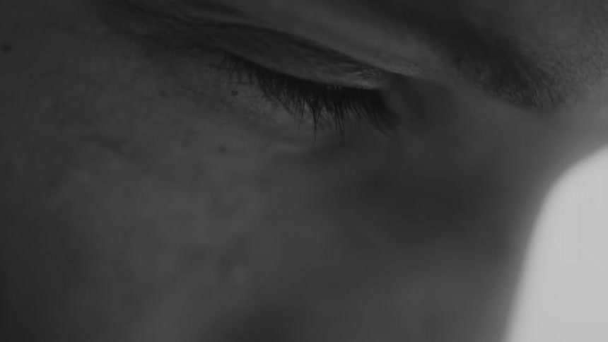 A man is closing his eyes and looks sad with emotion