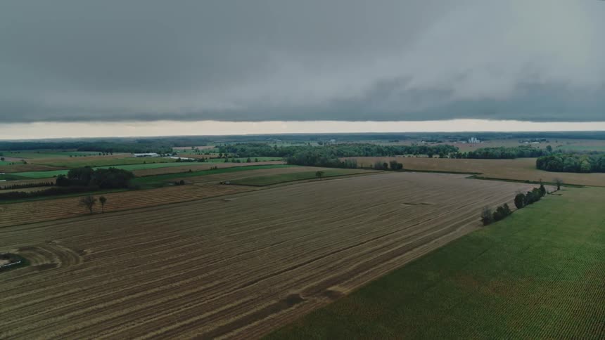 Large rural area with cultivated fields under a stormy sky