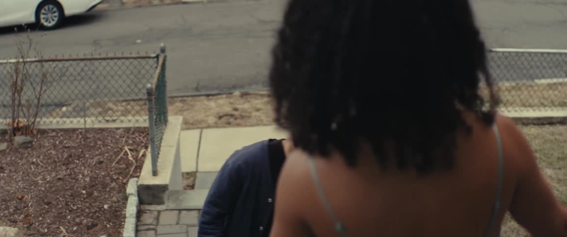 Man being surprised to see a woman in a dress like that on the stairs of a house outside