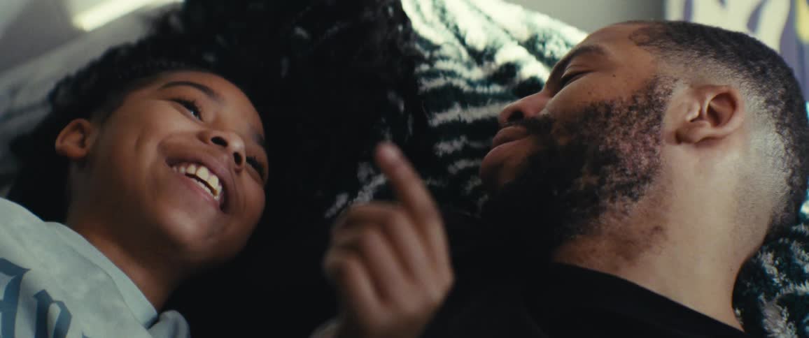 Father and daughter lying in bed talking