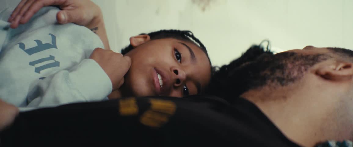 Father and daughter lie in bed in a sunlit room happily relaxed talking to each other