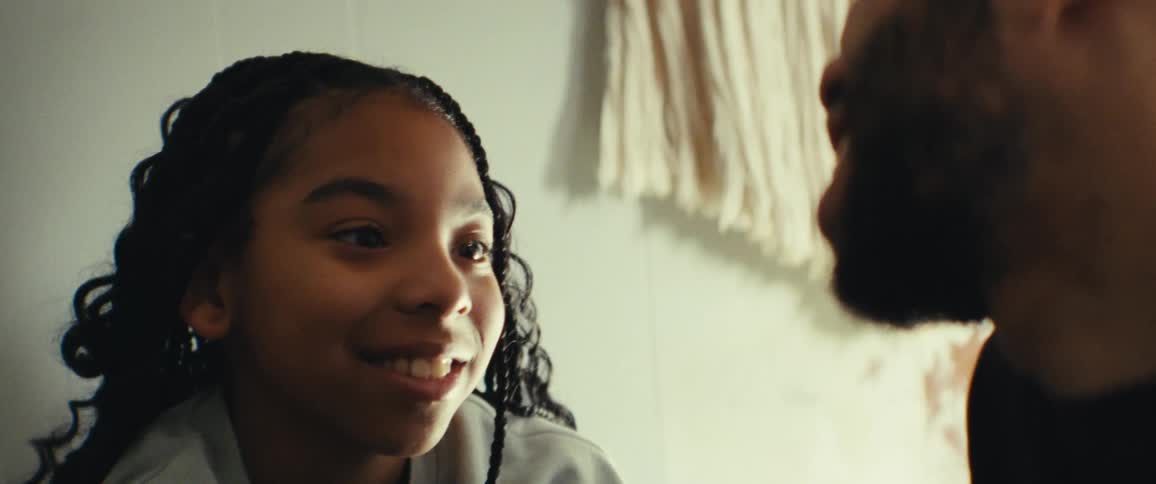 Father and daughter talking to each other in a sunlit room