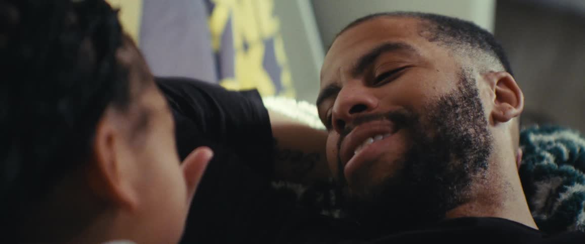 Portrait of a bearded man sitting and talking to another person next to him