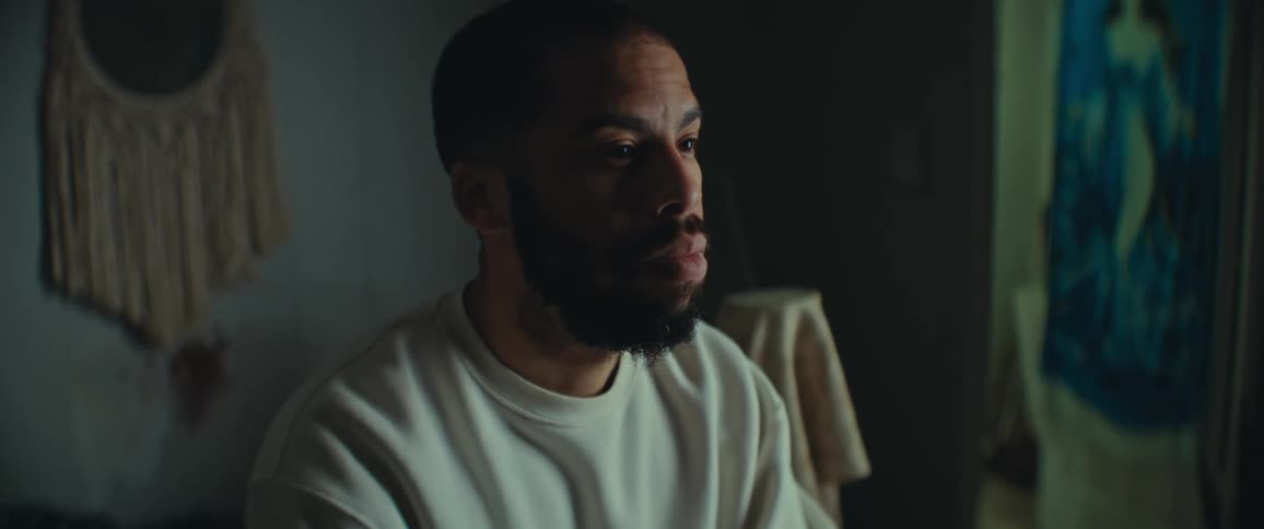 Deep in thought a man is sitting in his bedroom