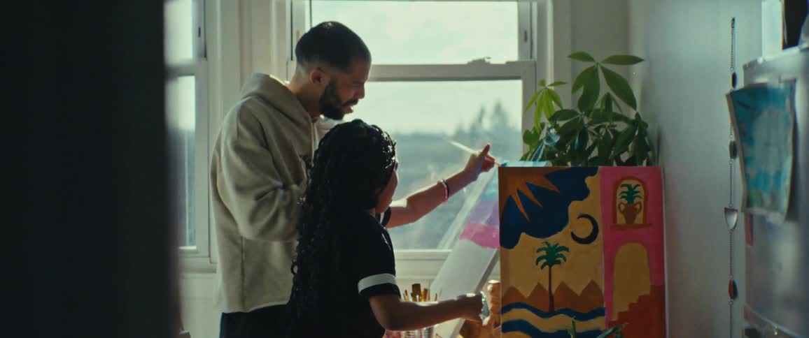 Father watching his daughter paint a picture