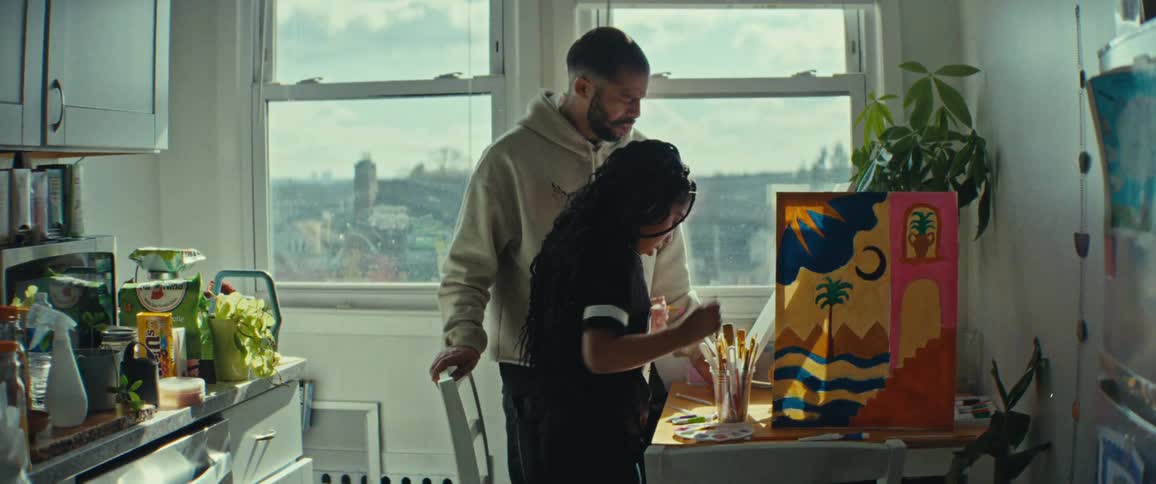 Father watching his daughter paint a picture