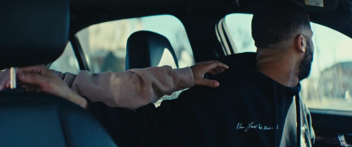 A girl is distracting a man by tapping him while he is driving