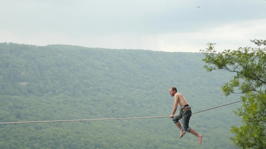 Man hanging on a wire suspended high in the air