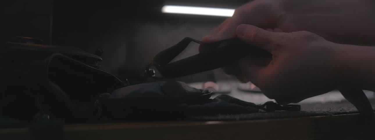 A person adjusts the knot on the bag strap