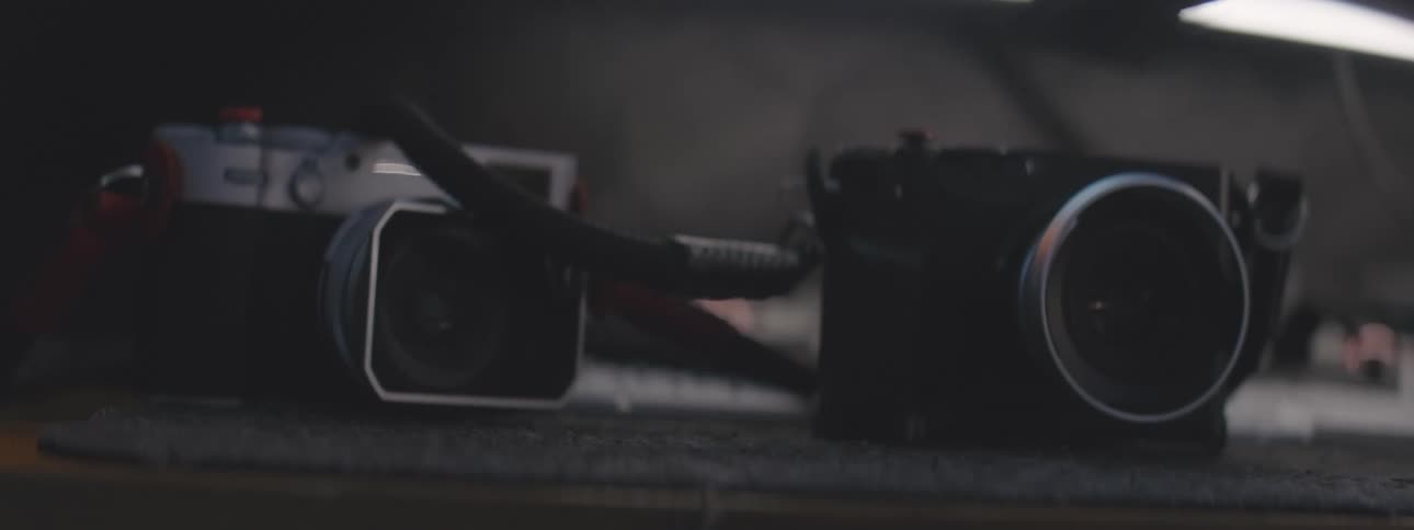 Hand picking up and returning a camera on a table