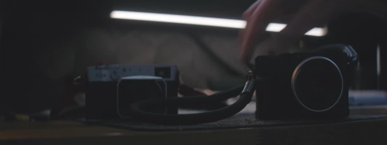 Hand placing a camera on top of a table
