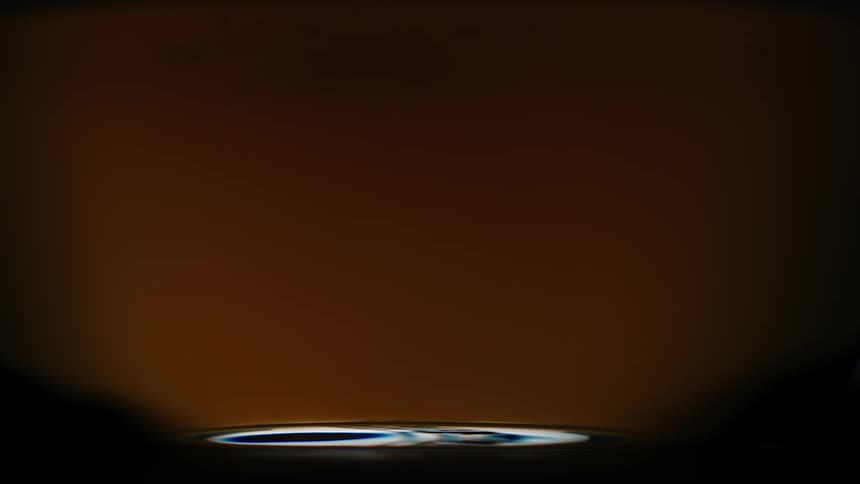 Brown liquid being poured into a glass mug