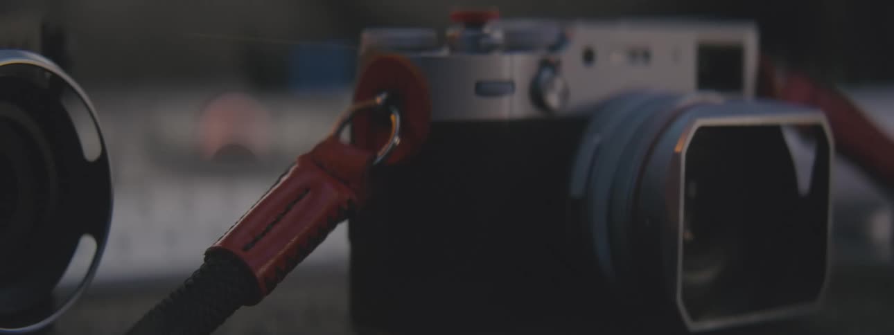 A photographic camera being placed next to a more current camera with a larger lens