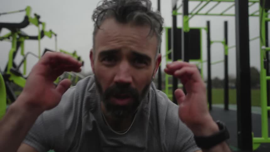 A man is doing sit ups in the park