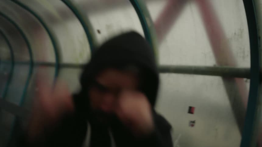 Man in hoodie raises fists in fighting stance
