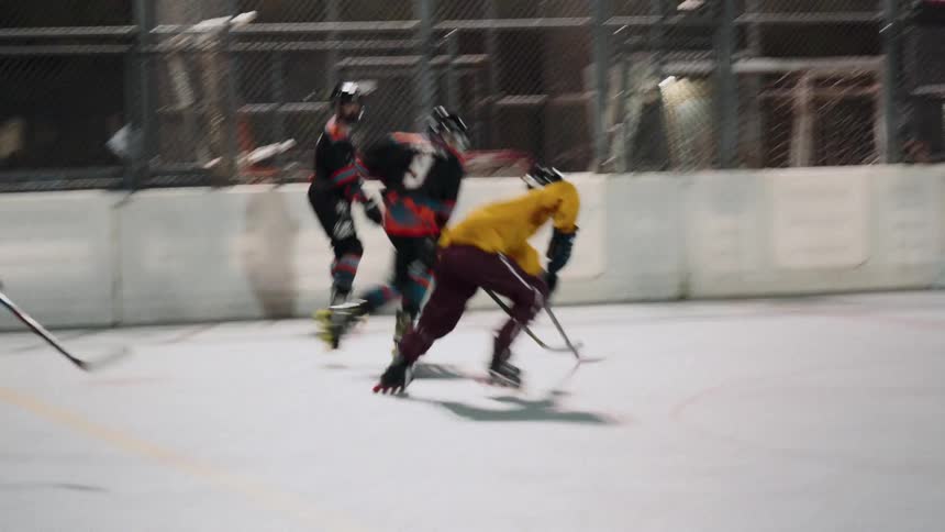 Hockey players race along the ice chasing the puck