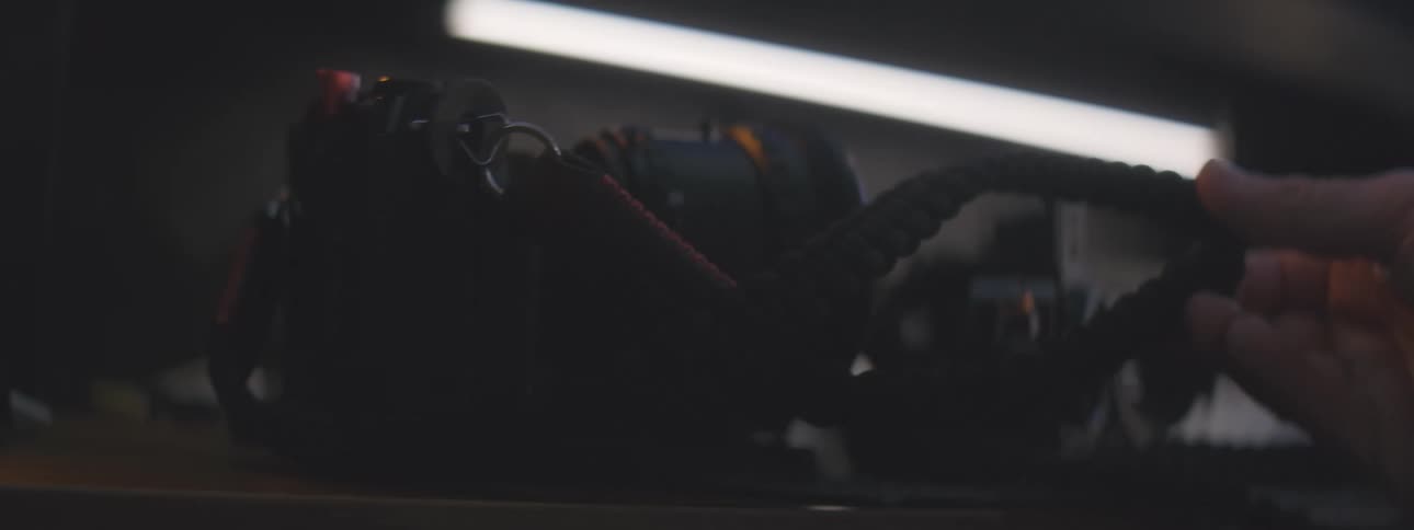 A person picks up the strap on the camera