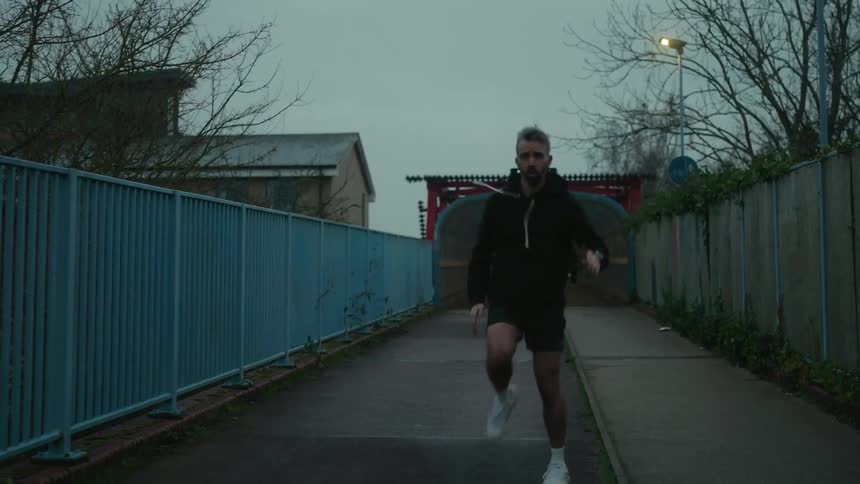 Man outdoors warming up his legs and starting to run