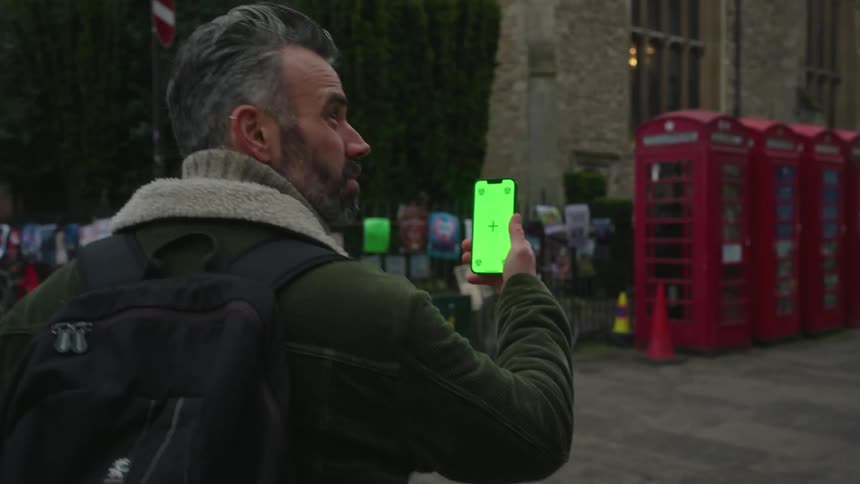 Man walking through the city holding a smartphone