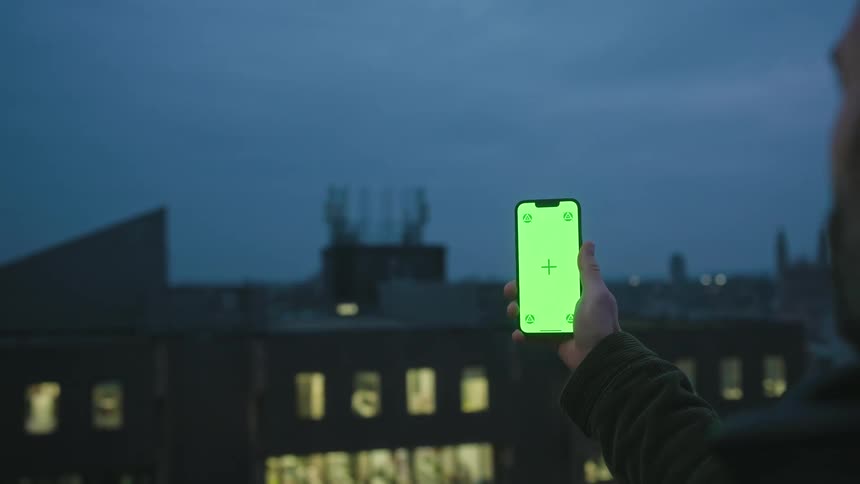 Man stretching his arm with his smartphone screen lit up