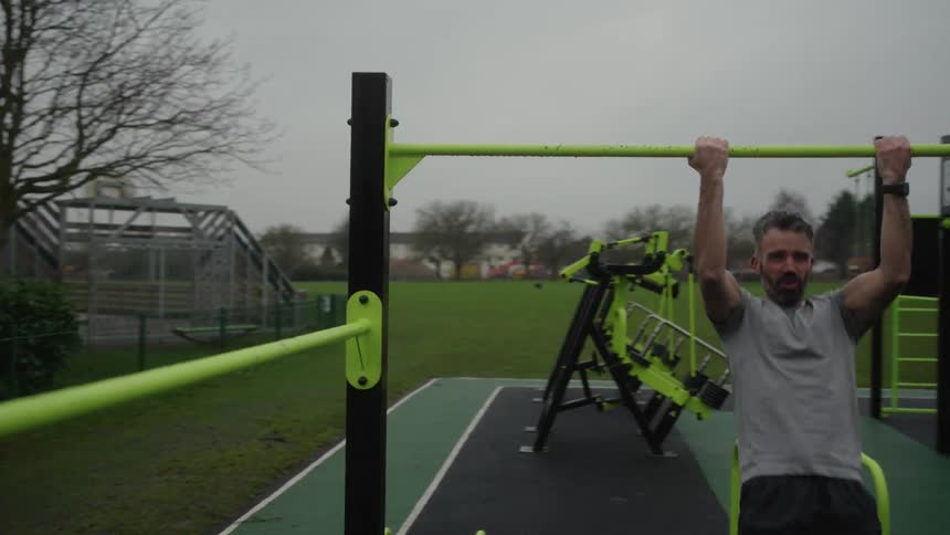Man is working out at an outdoor gym during the spring