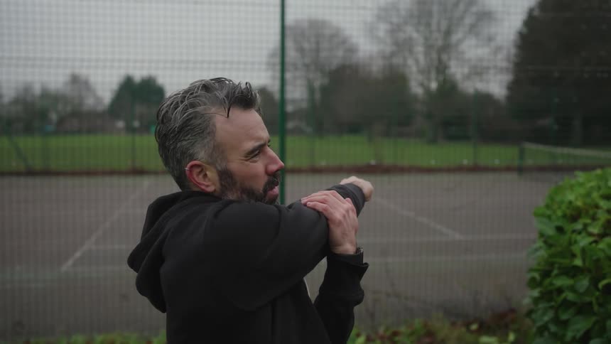Man in black sweatshirt stretching his body