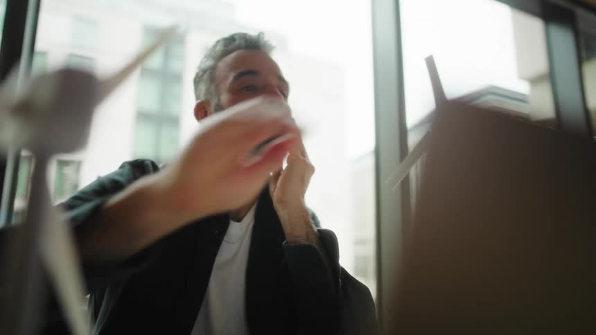A tired man closes his laptop