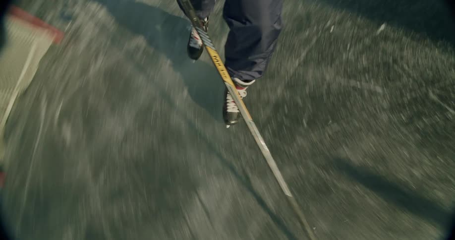 A person is ice skating on a frozen surface viewed from a topdown perspective