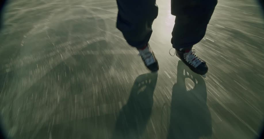 A hockey player is moving fast on the ice