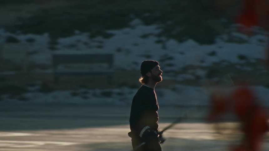 A man cheers and lifts his hockey stick above his head