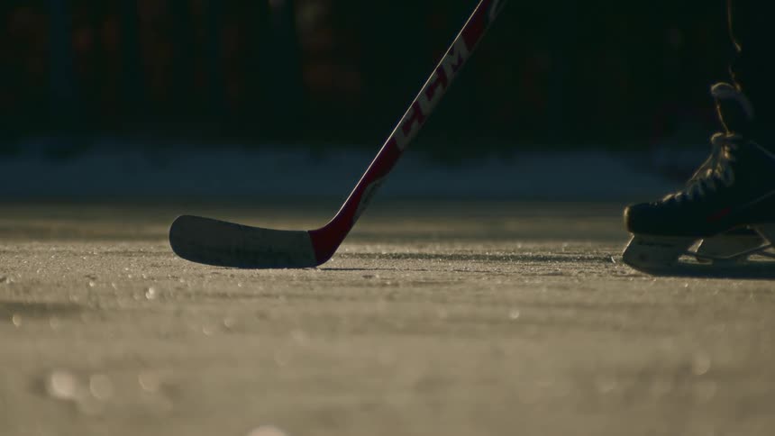 A man catches the puck on the ice with his hockey stick