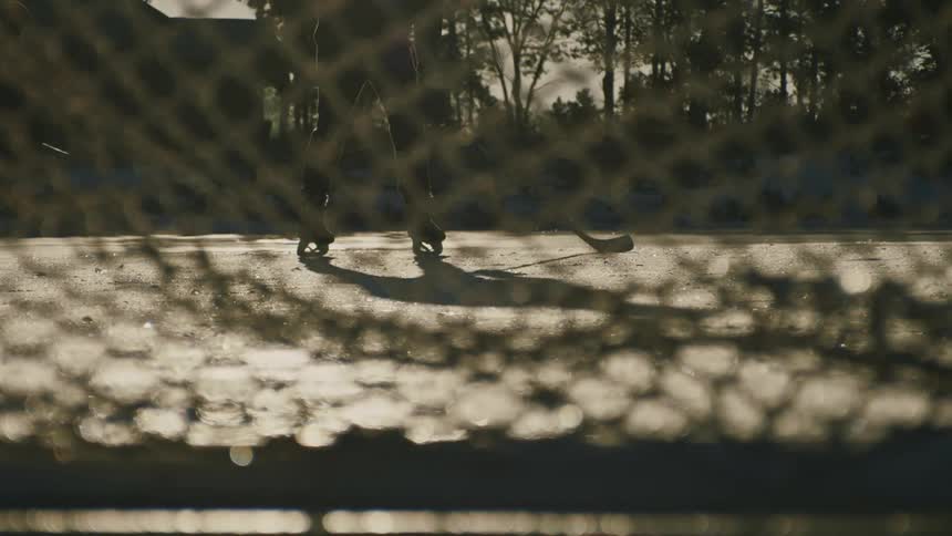 Ice hockey player seen through goal net