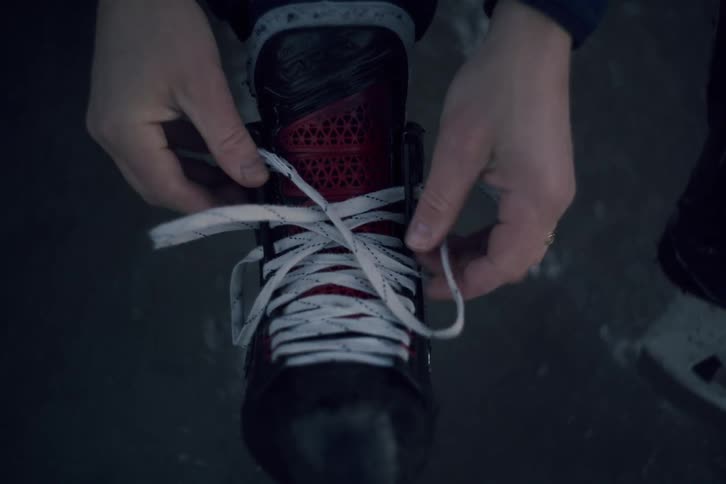 Man laces up his ice skate