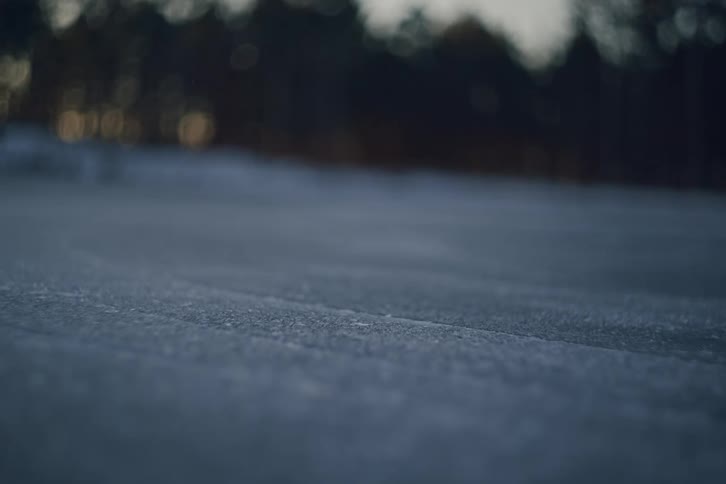 Hockey player glides quickly across the outdoor ice during dusk