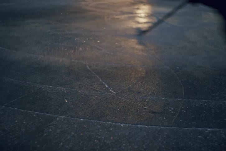Skating rapidly in circles on hockey skates outdoors at night