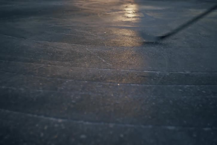 A person holding a hockey stick gliding across an ice surface