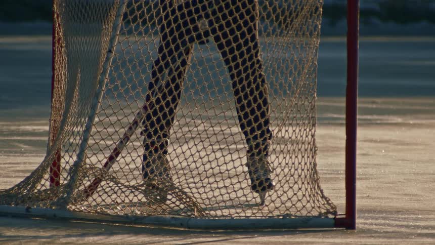 Two people play hockey outdoors