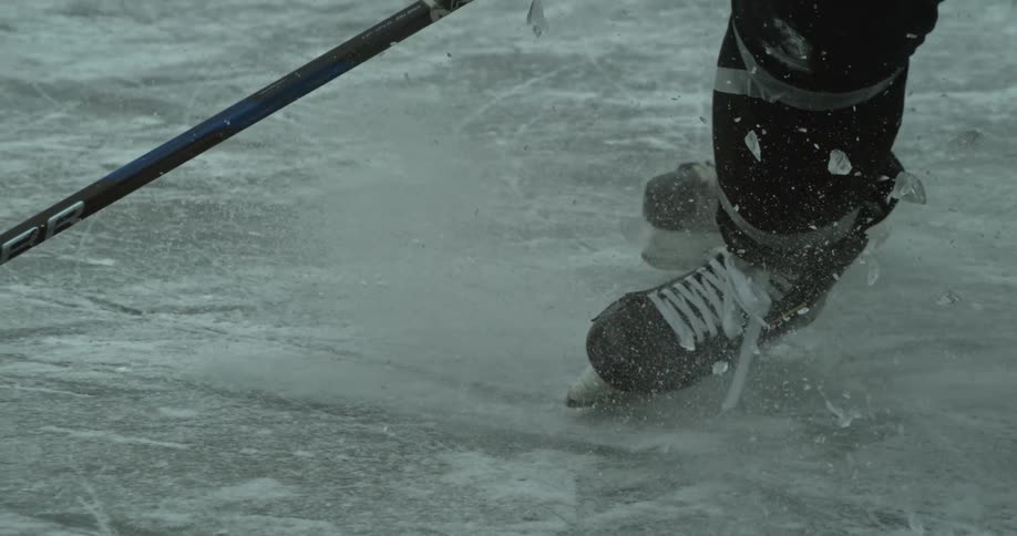 Ice particles fly through the air while two hockey players play hockey