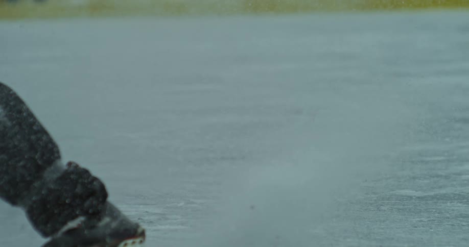 A man reaches for the puck with his hockey stick