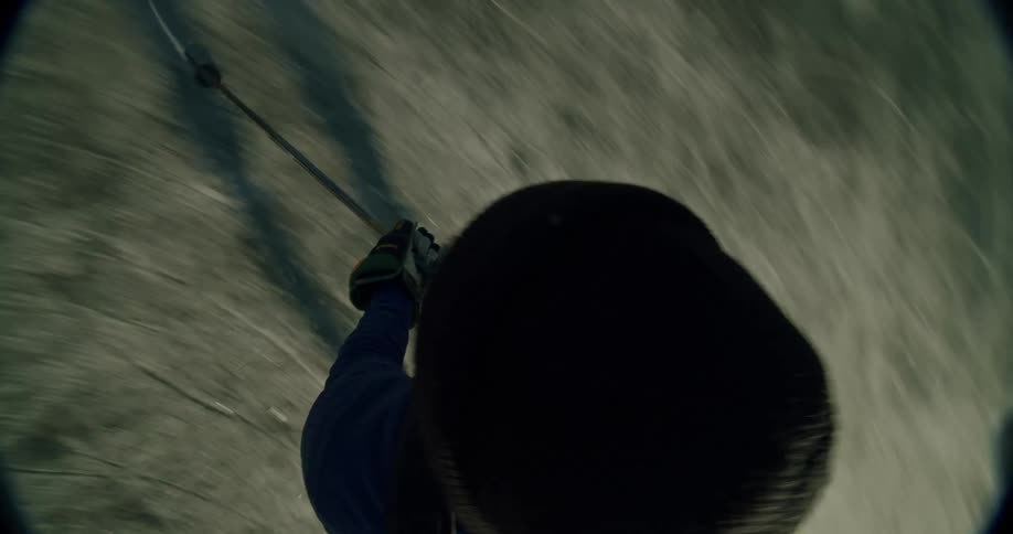 A hockey player wearing a beanie skates and stickhandles filmed from a low first person perspective