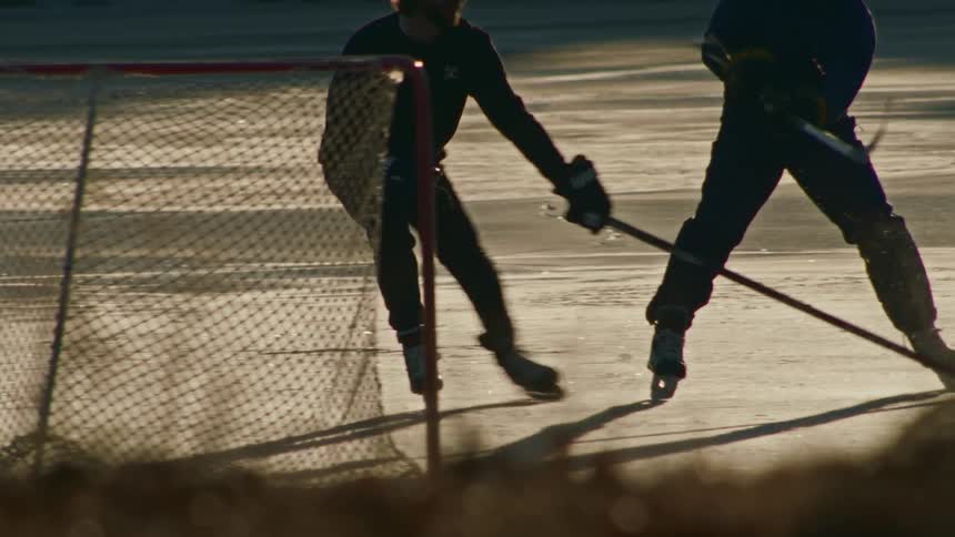 Two men compete to get the puck in a hockey game