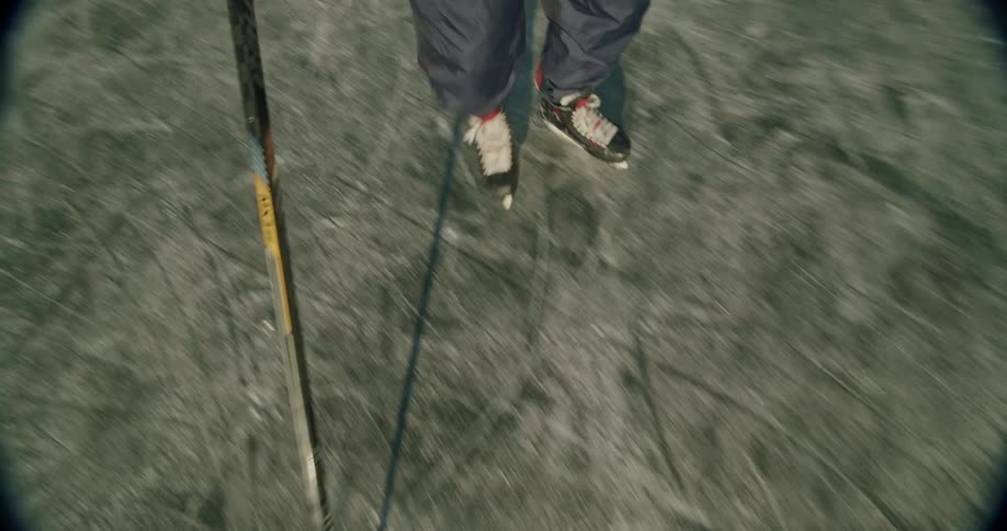Hockey player skates on the ice holding a stick