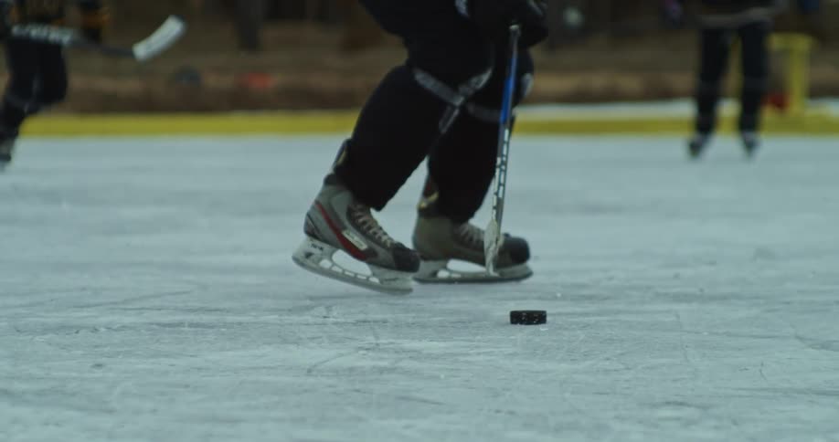 A player slides the puck along the ice with his hockey stick