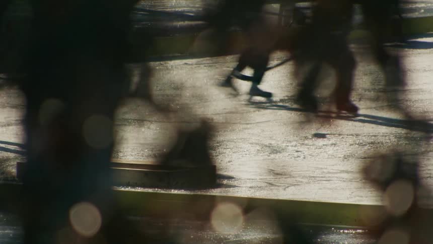 Athletes play a hockey game on an outdoor ice rink