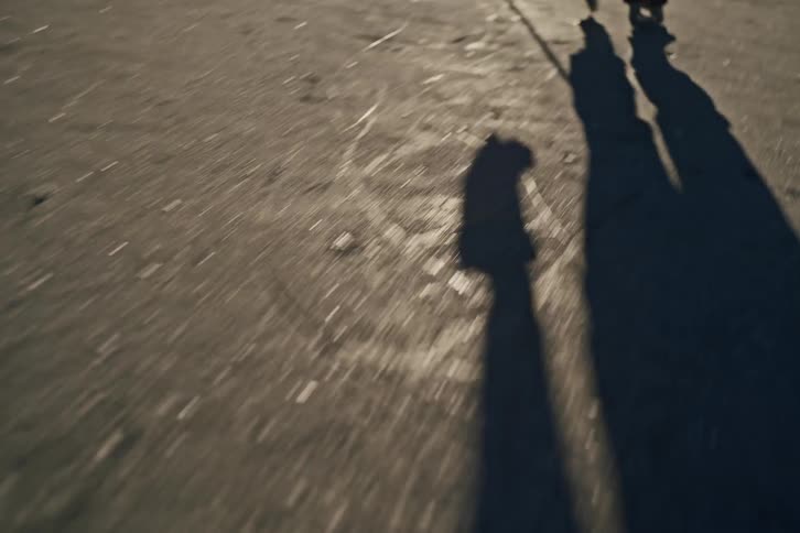 Legs of a person sliding across an outdoor ice rink playing hockey